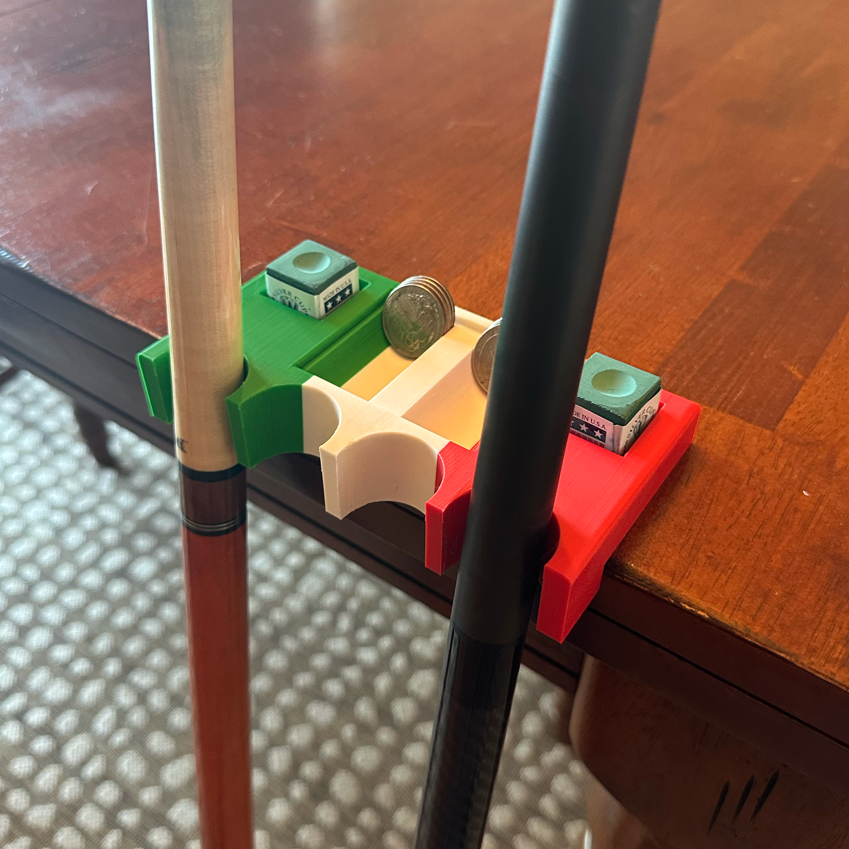 Mexican flag pool cue holder with four cue slots, chalk storage, and quarter compartments on a bar table.